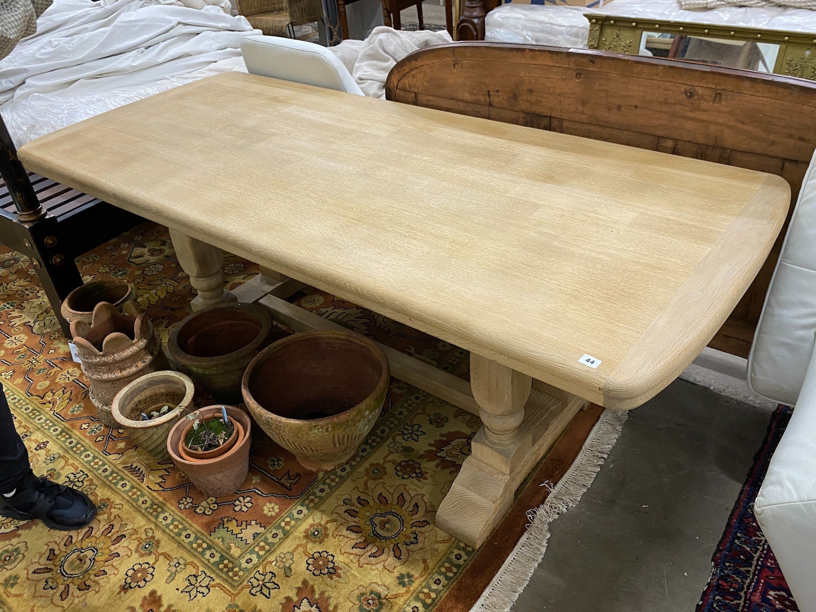 A rectangular bleached oak refectory dining table on four turned pillars with central stretcher, 210cm, width 89cm, height 75cm